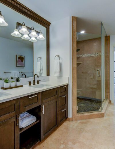 A bathroom with two sinks and a large mirror.
